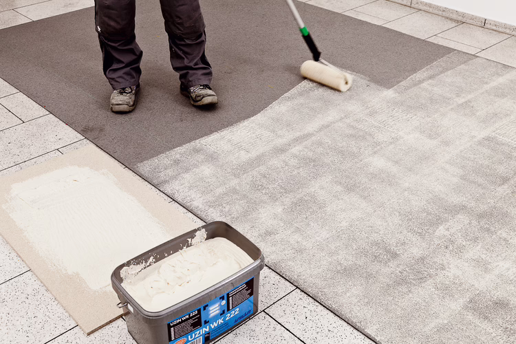 Breng UZIN WK 222 aan op de ondergrond en de vloerbedekking met de bijgeleverde gele structuurroller. Gebruik voor randen en kanten de UZIN siliconenkwast. Rol voor een gelijkmatige verdeling van de lijm de structuurroller eerst uit op bijvoorbeeld een stuk hout of spaanplaat.