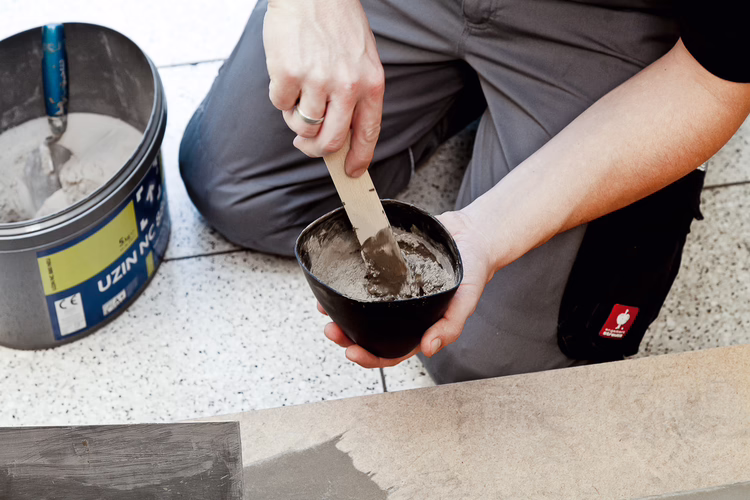 Oneffenheden uitvlakken met UZIN NC 880 Turbo reparatiemortel. Meng UZIN NC 880 in een schone emmer met schoon, koud water tot een homogene massa. Maak niet te veel mortel in een keer aan, zorg dat deze binnen 5-10 minuten verwerkt wordt.